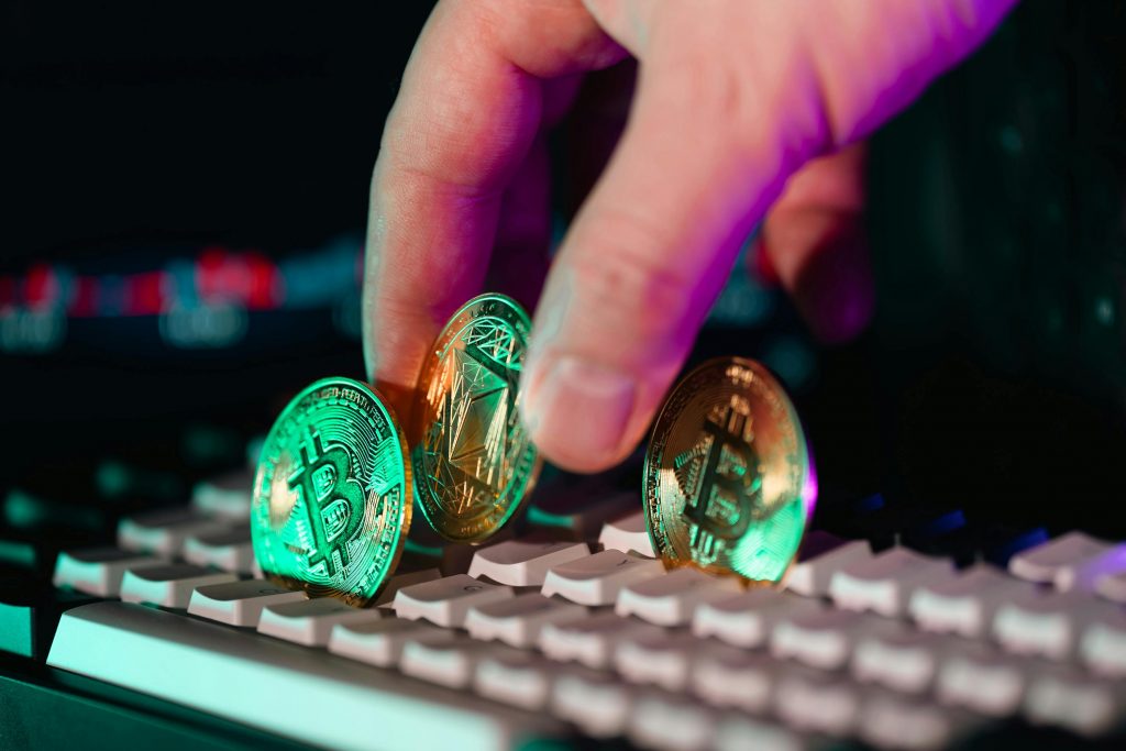 Close-up of cryptocurrency coins on a keyboard with a hand, symbolizing digital currency and finance technology.